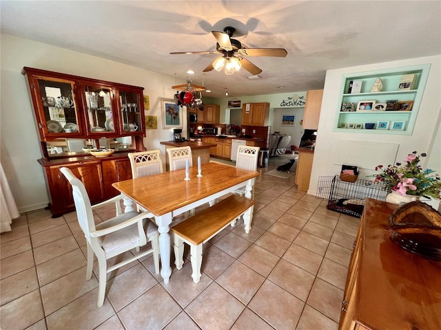 dining room with ceiling fan, built in shelves, and light tile patterned flooring