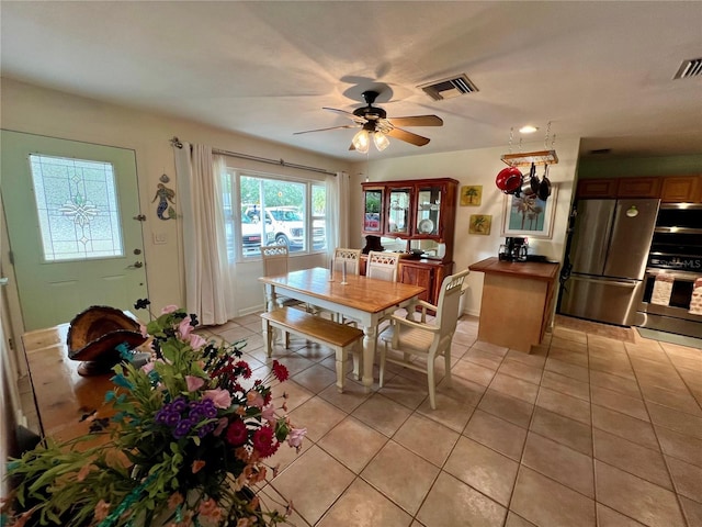 dining space with ceiling fan and light tile patterned floors