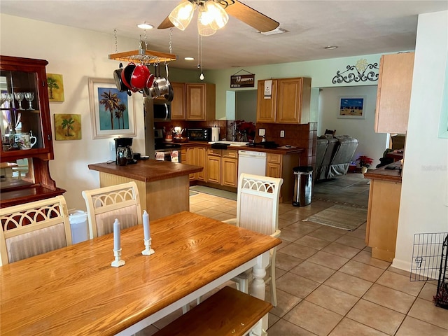 kitchen with decorative backsplash, ceiling fan, kitchen peninsula, white dishwasher, and light tile patterned floors