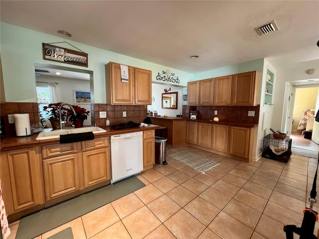 kitchen featuring light tile patterned floors, tile countertops, decorative backsplash, white dishwasher, and sink