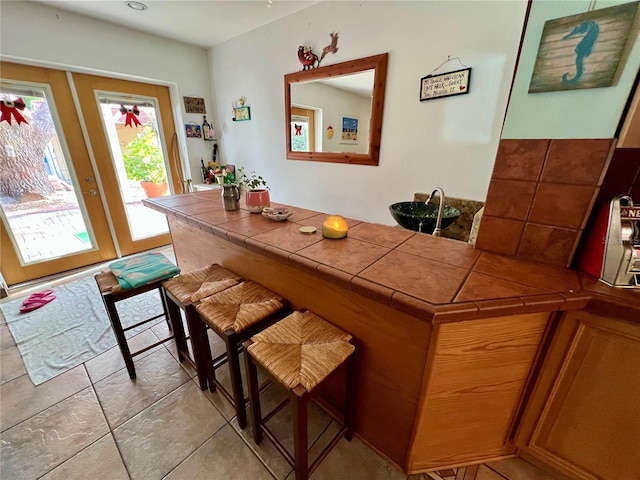 bar with tile counters and light tile patterned floors