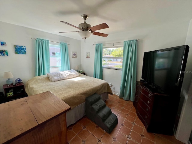 tiled bedroom with ceiling fan and multiple windows