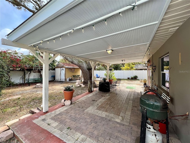 view of patio with a grill and a storage shed