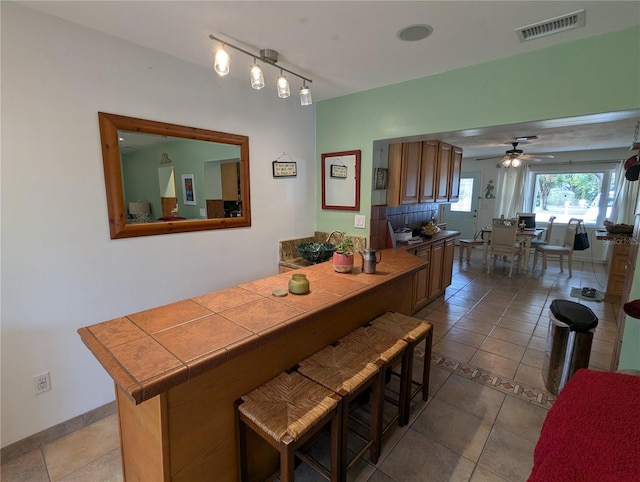 dining space featuring ceiling fan and tile patterned flooring