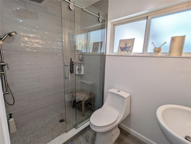 bathroom with sink, toilet, and a shower with door