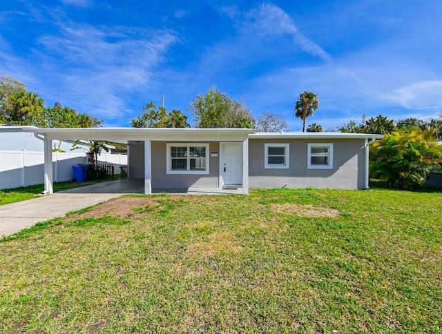 ranch-style home featuring a front lawn and a carport