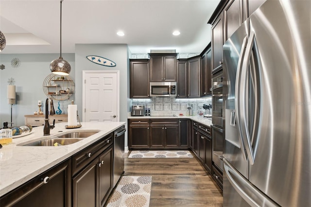 19315 Hawk Valley Dr, Tampa, FL 33647 - kitchen featuring sink, hanging light fixtures, dark wood-type flooring, stainless steel appliances, and decorative backsplash