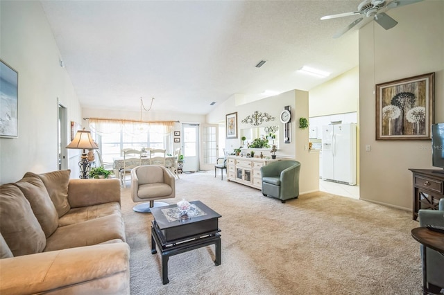 carpeted living room featuring ceiling fan and vaulted ceiling