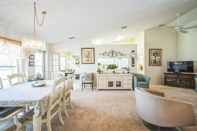 dining room with a textured ceiling, light carpet, ceiling fan with notable chandelier, and lofted ceiling