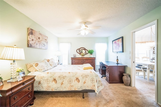 bedroom with light carpet, a textured ceiling, and ceiling fan