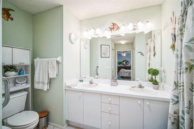 bathroom with vanity, toilet, and a textured ceiling