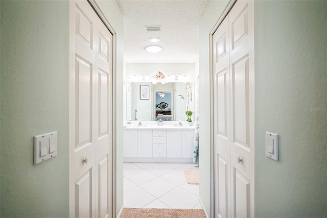 bathroom featuring tile patterned floors, vanity, and a textured ceiling