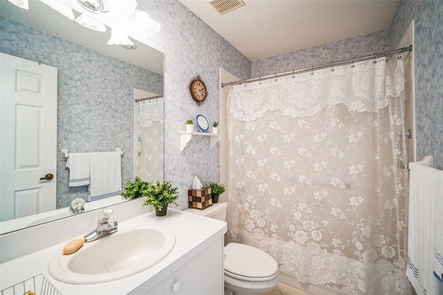 bathroom featuring curtained shower, vanity, a textured ceiling, and toilet