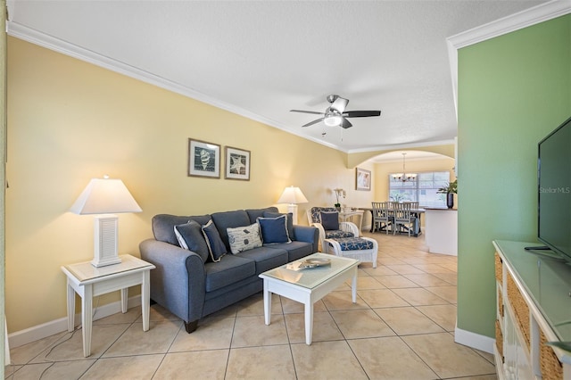 tiled living room with ceiling fan with notable chandelier and ornamental molding