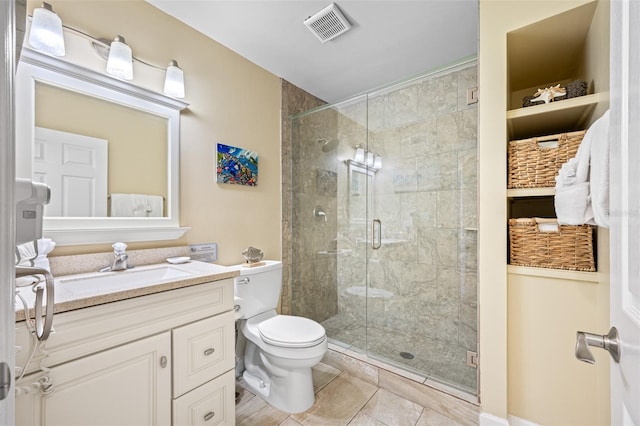 bathroom with tile patterned flooring, a shower with door, vanity, and toilet