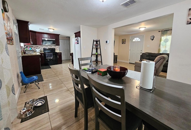 tiled dining space featuring a textured ceiling