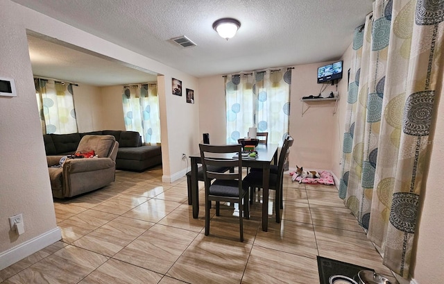 dining area featuring a healthy amount of sunlight and a textured ceiling