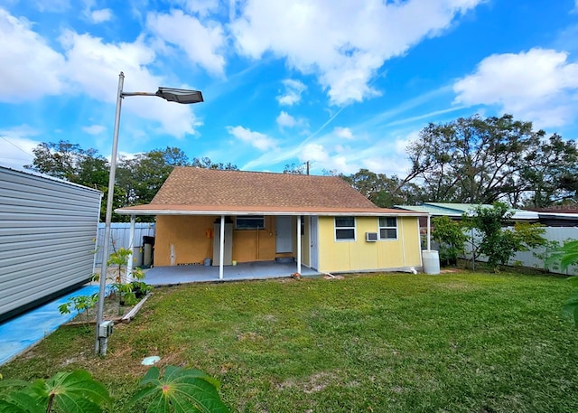 back of house with a lawn and a patio