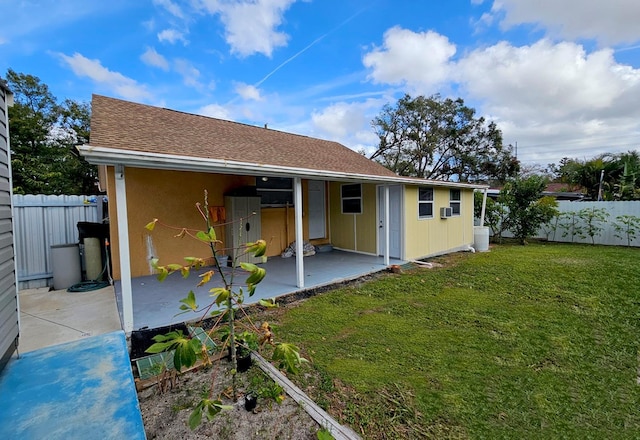 back of house featuring a lawn and a patio