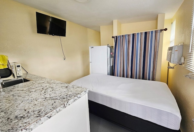 bedroom featuring cooling unit and white fridge