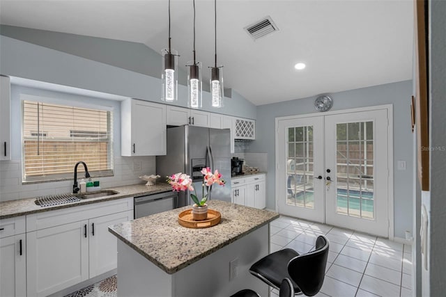 kitchen with a center island, backsplash, french doors, sink, and stainless steel appliances