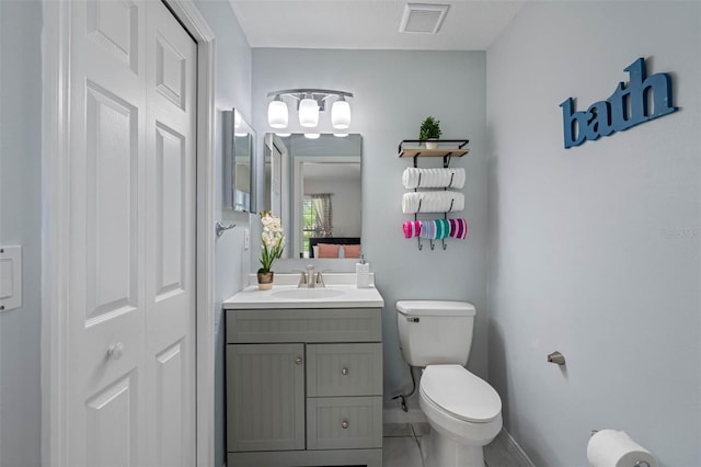 bathroom featuring tile patterned flooring, vanity, and toilet