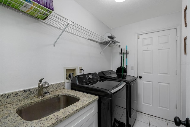 washroom with washer and dryer, light tile patterned floors, cabinets, and sink