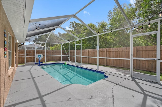 view of swimming pool with glass enclosure and a patio area