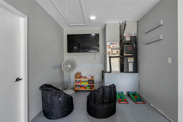 recreation room with a textured ceiling