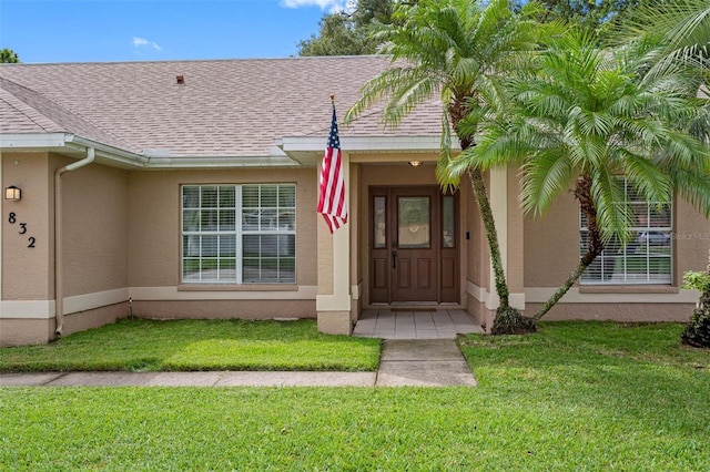 view of exterior entry with a yard