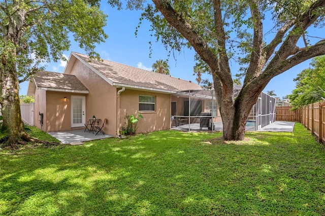 back of property with a lawn, a lanai, and a patio