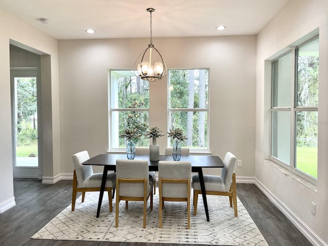 dining room with dark wood-type flooring, a chandelier, and a wealth of natural light