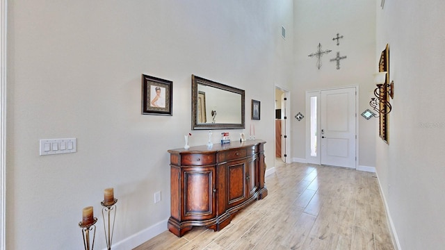 foyer with a high ceiling and light wood-type flooring