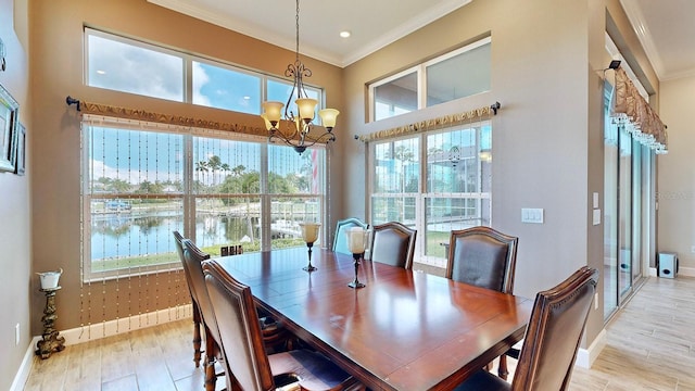 dining area featuring a chandelier, a water view, crown molding, and a healthy amount of sunlight