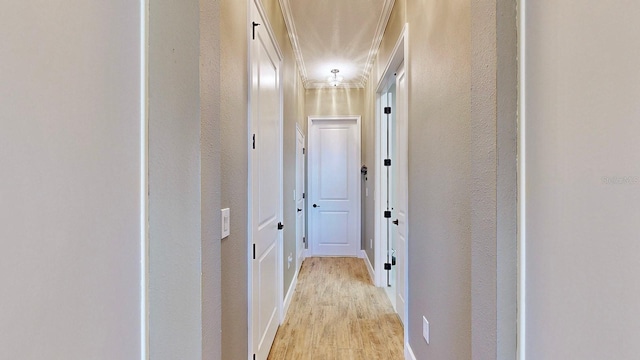 hallway featuring crown molding and light hardwood / wood-style flooring