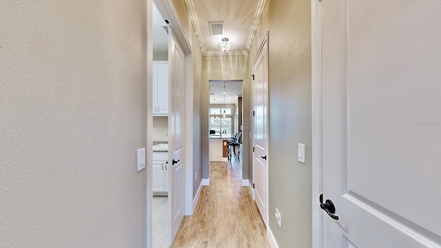 hallway featuring crown molding and light wood-type flooring