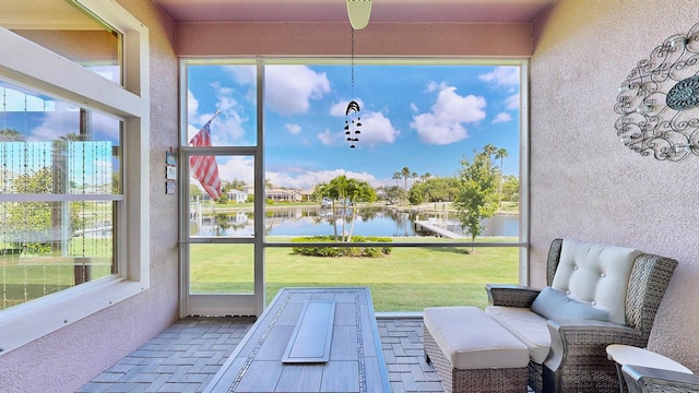 sunroom featuring a water view