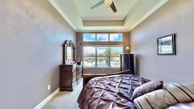 bedroom featuring a raised ceiling, ceiling fan, and light carpet