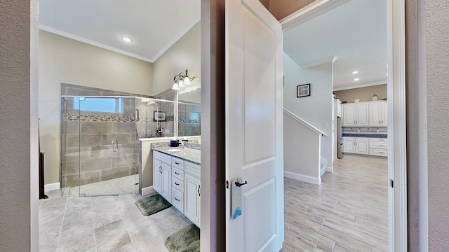 bathroom with vanity, an enclosed shower, and crown molding