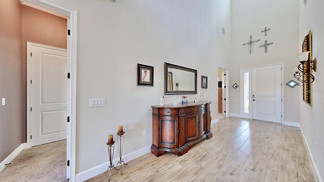 entryway with a high ceiling and light wood-type flooring