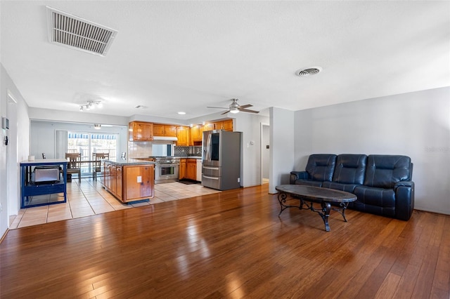 living room with light hardwood / wood-style floors and ceiling fan