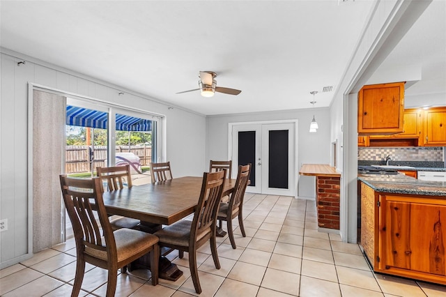 dining room with light tile patterned floors, ceiling fan, ornamental molding, and sink