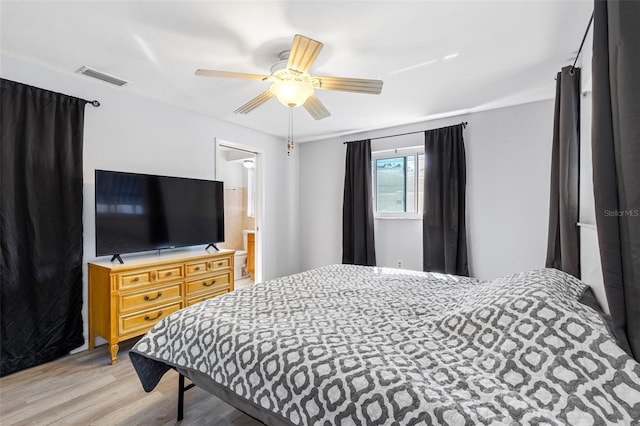 bedroom with ceiling fan, light wood-type flooring, and connected bathroom