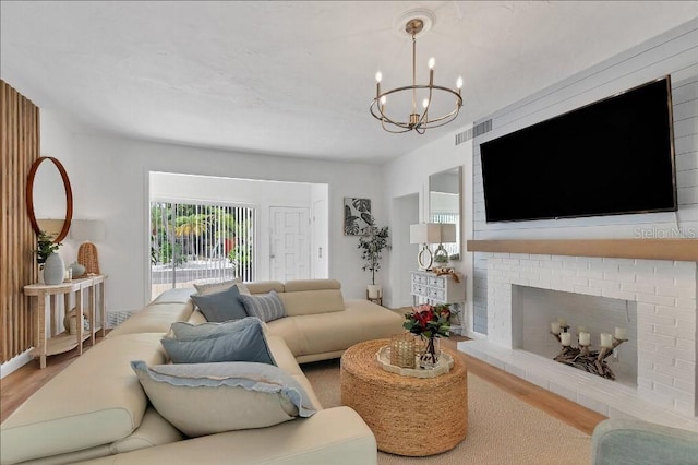 living room featuring a fireplace, wood-type flooring, and a chandelier