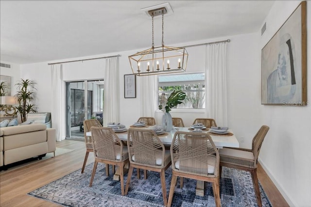 dining room with a chandelier and light wood-type flooring