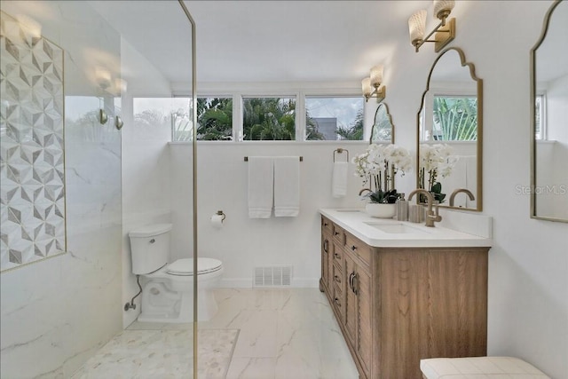 bathroom featuring vanity, a healthy amount of sunlight, and toilet