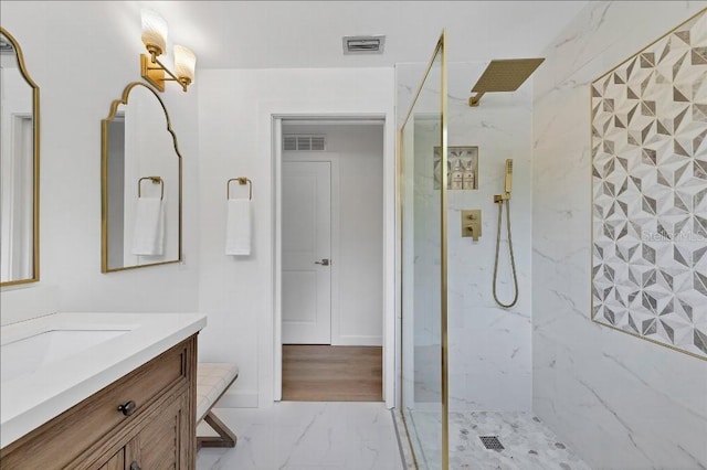 bathroom featuring tiled shower and vanity