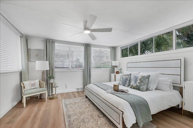 bedroom with radiator, ceiling fan, and light hardwood / wood-style flooring