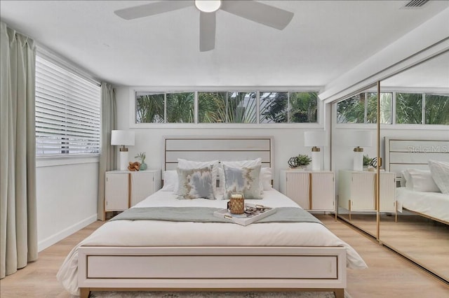 bedroom with a closet, light hardwood / wood-style flooring, and ceiling fan