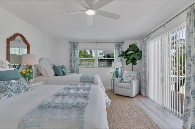 bedroom featuring ceiling fan, light wood-type flooring, and multiple windows